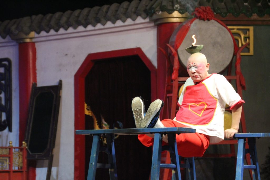 This is a photo of a man balancing a bowl of fire on his head.